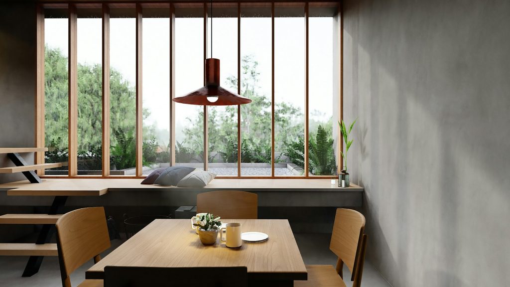 Eethoek met houten tafel, stoelen en een donkere hanglamp voor een groot raam