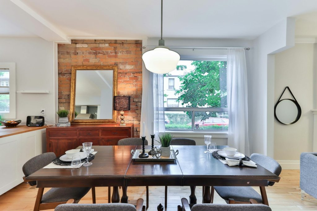 Eetkamer met lange houten tafel en een witte bolvormige hanglamp