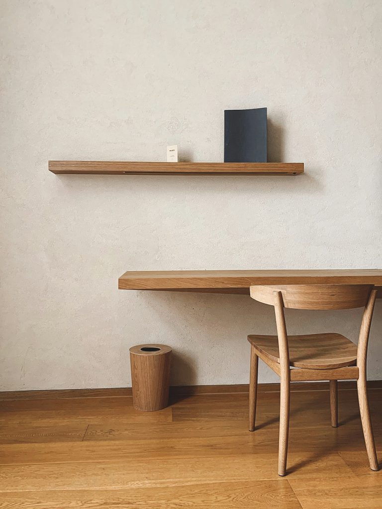 Houten wandplank en bureau tegen een lichte muur