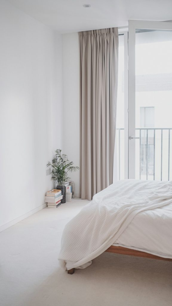 Licht slaapkamerhoekje met een opgemaakt bed bij een raam