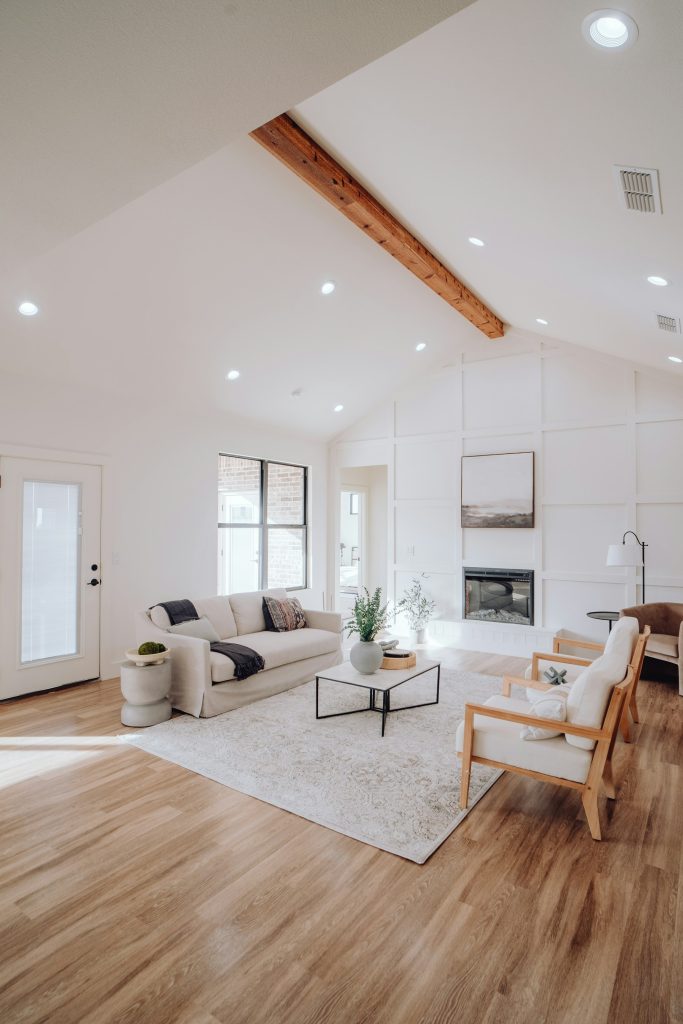 Lichte woonkamer met een witte bank, lage tafel en grote ramen