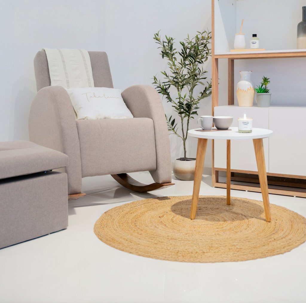 Rond jute vloerkleed onder een schommelstoel en een wit bijzettafeltje