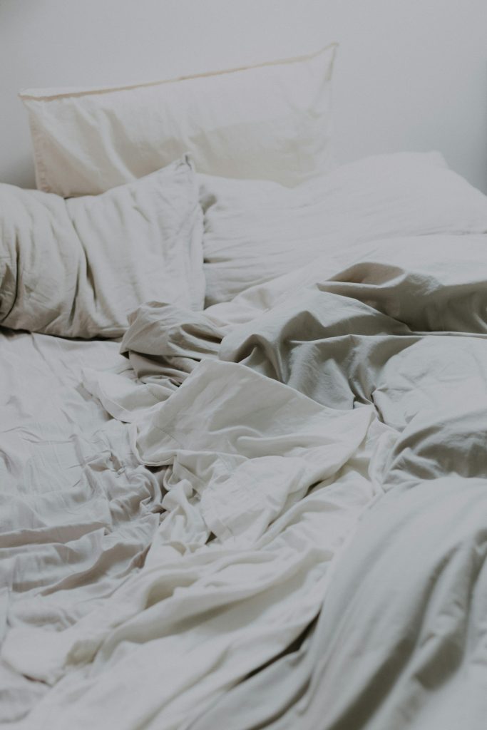 Verfrommeld wit beddengoed op een bed