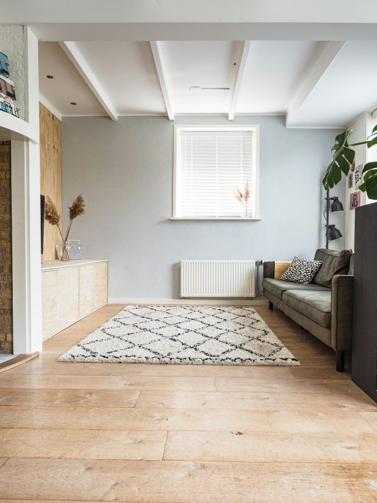 Wit berber vloerkleed met zwart ruitpatroon in een lichte woonkamer